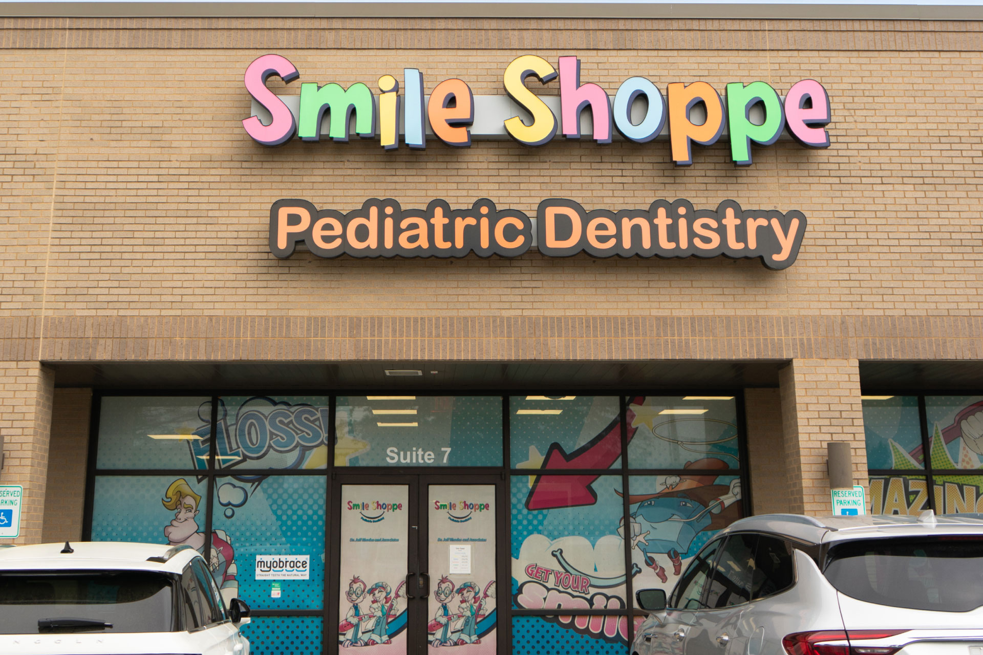 Smile Shoppe Fayetteville exterior in shopping center with logo on brick wall above doors